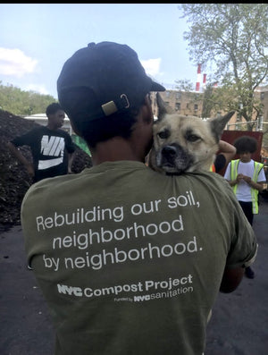 man with NYC compost project shirt holding a dog